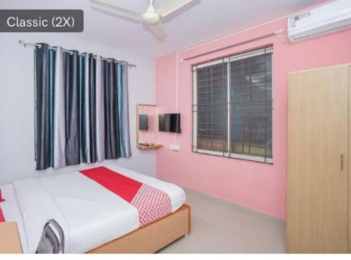 Schlafzimmer mit einem Bett und einem Fenster in der Unterkunft Hotel City Plaza in Bangalore