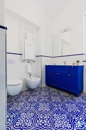 a bathroom with a blue and white tile floor and a tub and sink at Hotel Da Raffaele in Ischia