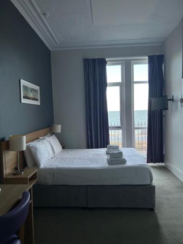 a bedroom with a bed and a large window at The Seafront Hotel by Compass Hospitality in Llandudno