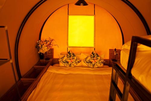 um pequeno quarto com uma cama e uma janela em Nirvana Retreat em Ras al-Khaimah