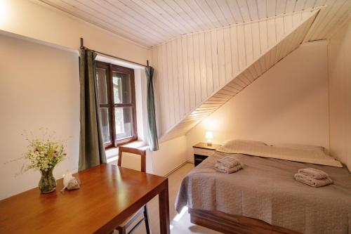 a bedroom with a bed and a table and a window at U Šumavských pramenů in Kašperské Hory