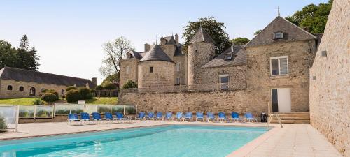 una casa con piscina di fronte a un castello di Manoir de Kerhuel de Quimper a Plonéour-Lanvern