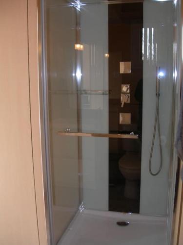 La salle de bains est pourvue d'une douche en verre et de toilettes. dans l'établissement Maison nature proche Bassin d'Arcachon, à Arès