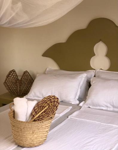 a bedroom with a bed with a basket on it at Mlango Paje House II in Paje