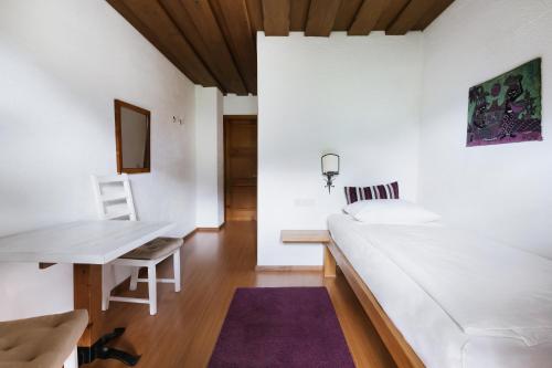 a white room with a desk and a bed at Sonnhof in Bad Ischl