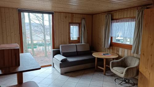 a living room with a couch and a chair and a table at Darázshegyi Faház in Mátraszentimre