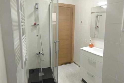 y baño con ducha acristalada y lavamanos. en Apartamento con vistas al puerto deportivo en Llanes