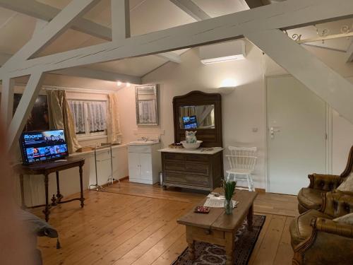 a living room with a couch and a table at B&B Petit Chateau - Stijlvol verblijf Centraal gelegen in Zeeuws Vlaanderen in Biervliet