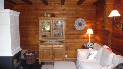 ein Wohnzimmer mit einem Sofa und einer Holzwand in der Unterkunft Ferienhaus Zur Einberger Schweiz in Rödental