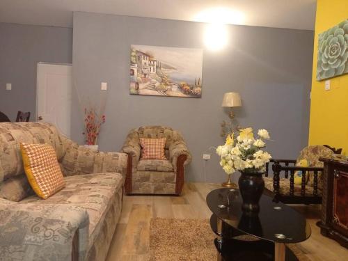 a living room with a couch and a table at RefleXion Views in Belle Garden