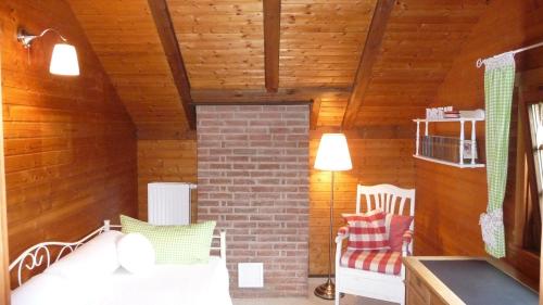 une chambre avec deux chaises et un mur en briques dans l'établissement Ferienhaus Zur Einberger Schweiz, à Rödental