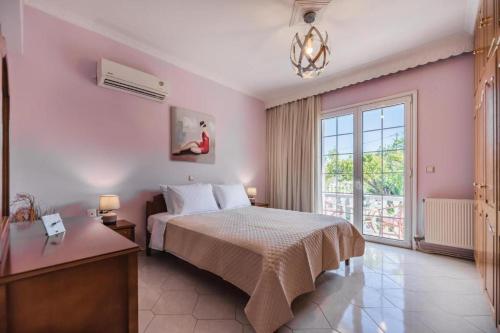 a bedroom with a bed and a large window at Casa Garden in Archangelos