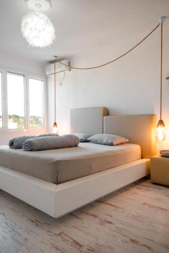 a bedroom with a large bed in a room with windows at Beachfront Marilyn in Durrës