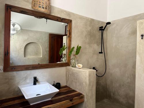 La salle de bains est pourvue d'un lavabo et d'un miroir. dans l'établissement Mlango Paje House II, à Paje