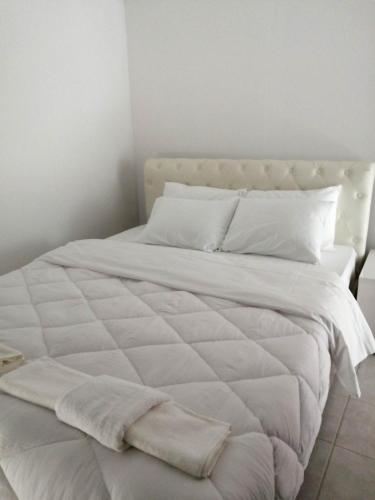 a large white bed with white sheets and pillows at Cozy Rodas House 1 in Skála