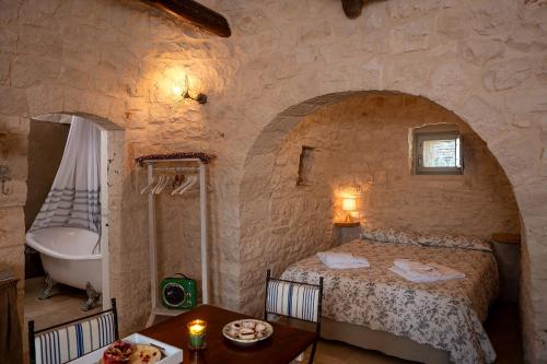a bedroom with a bed and a tub and a table at Le Dieci Porte in Alberobello