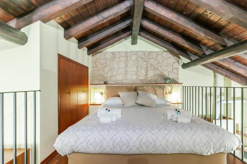 a bedroom with a large bed with wooden ceilings at RHOme 24 - cozy attic at Rho Fiera in Rho