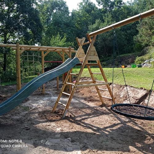a playground with a slide and a swing at Apartmány U Orlického jezera - Kamenice in Klučenice