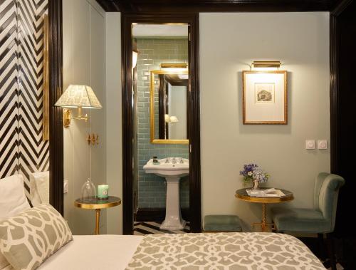 a bedroom with a bathroom with a sink and a bed at Triana House in Seville