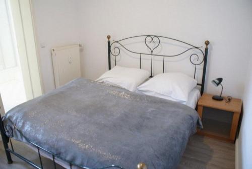 1 cama con marco de metal y almohadas blancas en Altstadtleben - ABC164 en Wismar