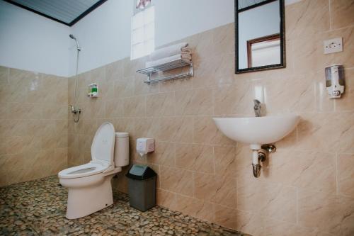 a bathroom with a toilet and a sink at The Dagan Bungalow in Nusa Penida
