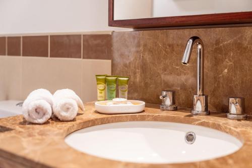 encimera con fregadero y toallas en Prime Retreats - 29 Emaar Boulevard Downtown Dubai, en Dubái