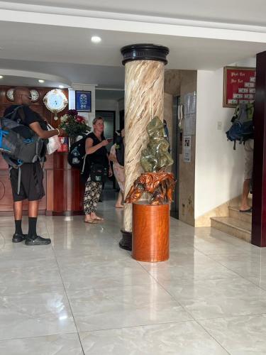 a group of people standing in a lobby with a column at Hà Tiên Hạnh Phúc Hotel in Ha Tien
