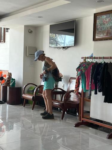 a woman standing in a store looking at her watch at Hà Tiên Hạnh Phúc Hotel in Ha Tien