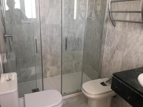 uma casa de banho com um WC e uma cabina de duche em vidro. em Apartment Panorama 2 em Altea