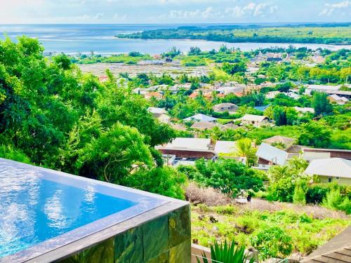 a view from the balcony of a house with a swimming pool at Villa Teranga avec vue panoramique sur la baie de Tamarin in Tamarin