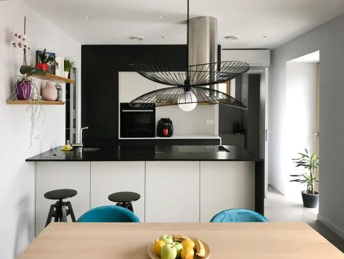 a kitchen with black and white cabinets and a table at Casa Matko in Kostanjevica na Krasu