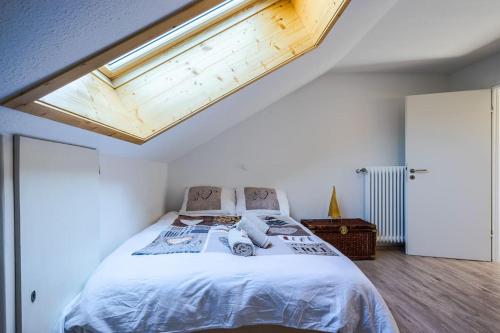 a bedroom with a large bed with a skylight at Newly renovated apartment in Bernau im Schwarzwald
