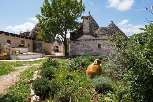 a garden in front of an old stone house at Le Dieci Porte in Alberobello
