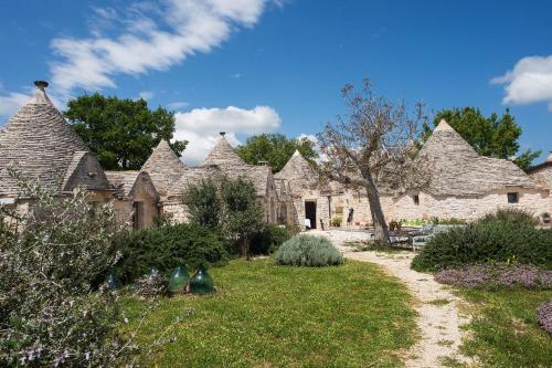 a group of stone houses with a grass yard at Le Dieci Porte in Alberobello