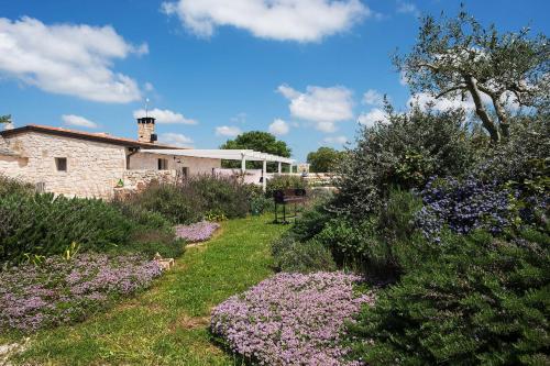 a garden with purple flowers in front of a building at Le Dieci Porte in Alberobello
