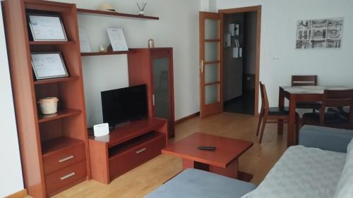 - un salon avec une télévision et une table dans l'établissement Apartamento terra1, à Caldas de Reis