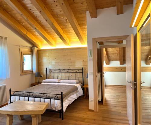 ein Schlafzimmer mit einem Bett und einer Holzdecke in der Unterkunft Chalet delle Dolomiti in Pieve di Cadore