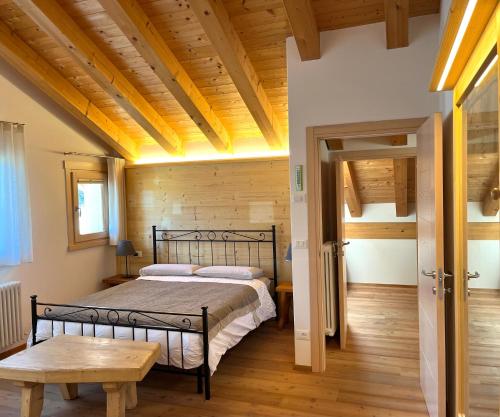 a bedroom with a bed and a wooden ceiling at Chalet delle Dolomiti in Pieve di Cadore