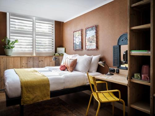 Un dormitorio con una cama y un escritorio con una silla. en Max Brown Hotel Museum Square, part of Sircle Collection, en Ámsterdam