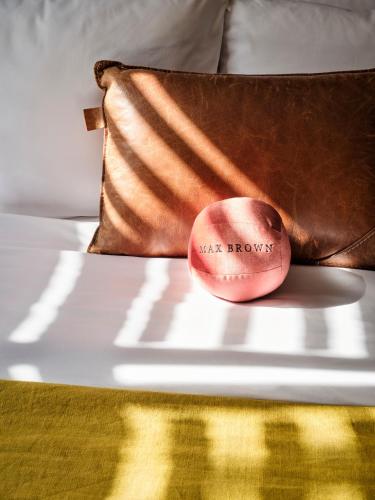 a pillow with the words waist brows on a bed at Max Brown Hotel Museum Square, part of Sircle Collection in Amsterdam