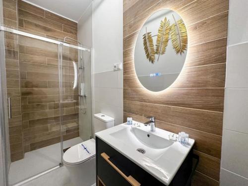 uma casa de banho com um lavatório, um WC e um espelho. em Chic 2BD Heaven in the Heart of Madrid em Madri
