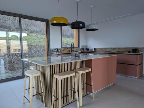 a kitchen with a large counter with stools around it at Chalet Coste Belle in La Fare-en-Champsaur