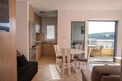 a kitchen and a living room with a table and chairs at Villa royale with shared pool in Hvar