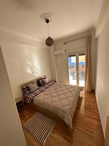 um quarto com uma cama e uma grande janela em Elegant XL Apartment In Koukaki em Atenas