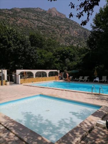 une grande piscine avec une montagne en arrière-plan dans l'établissement MOBIL HOME CAMPING 3***, à Villefranche-de-Conflent