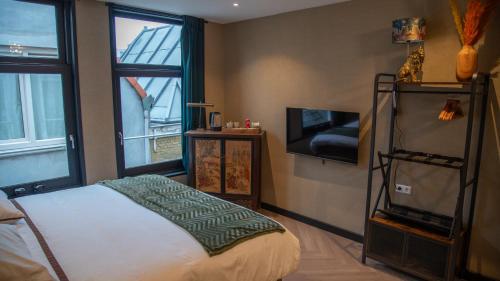 a bedroom with a bed and a tv and a window at Downtown Suite in The Hague