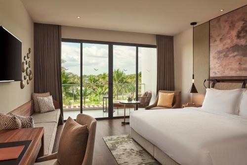 a hotel room with a bed and a living room at Mövenpick Resort Waverly Phu Quoc in Phu Quoc