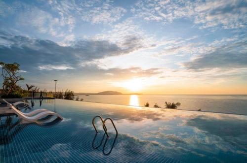 a swimming pool with a view of the ocean at Apec MANDALA CHAM BAY MUI NE SPA RESORT AND CONDOTEL in Ấp Thiẹn Ái
