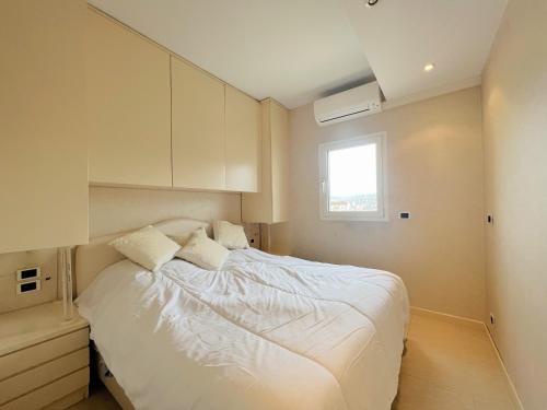 une chambre avec un lit avec des draps blancs et une fenêtre dans l'établissement Colony apartment with parking, by Welcome to Cannes, à Cannes