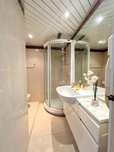 une salle de bain blanche avec une douche et un lavabo dans l'établissement Colony apartment with parking, by Welcome to Cannes, à Cannes